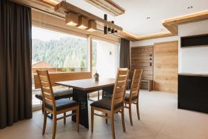a dining room with a table and chairs and a large window at Apart Auriga in Fiss