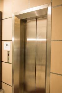 un ascensore in acciaio inossidabile in una stanza di Swan Garden Hotel a Pasir Gudang
