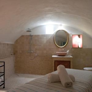 a bathroom with a bed and a sink and a mirror at Les Horizons - SPA-JACUZZI - MASSAGE- SAUNA - 4 SAISONS - Piscine chauffée Toute l'année - 800m centre ville Nyons in Nyons +114 photos