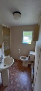 a bathroom with a toilet and a sink at Domki Holenderskie Mazury Leleszki in Leleszki