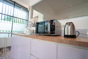 a microwave sitting on a counter in a kitchen at Bobopod Slamet Riyadi, Solo in Solo