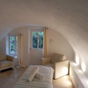 a white room with a bed and a couch at Domaine La Tour - SPA - Jacuzzi - Sauna - Massage - 4 SAISONS - Piscine Chauffée Toute l'année - Heated POOL - 800m City Centre Nyons in Nyons