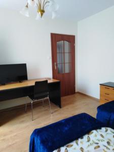 a bedroom with a desk and a bed and a desk at Piernikowy Dworek in Lubicz