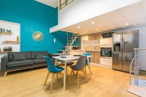 een keuken met een tafel en stoelen en een bank bij Le Patio - SRLoc in Dijon