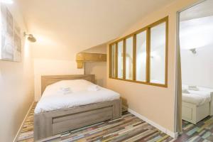 een kleine slaapkamer met twee bedden en een raam bij Le Patio - SRLoc in Dijon