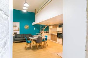 een keuken en woonkamer met een tafel en stoelen bij Le Patio - SRLoc in Dijon +3 foto's