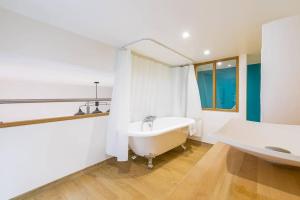 een witte badkamer met een bad en een wastafel bij Le Patio - SRLoc in Dijon