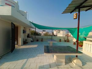 patio z zielonym namiotem na dachu budynku w obiekcie VILLA DE SRIVAARI RESIDENCY w mieście Puducherry