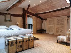 1 dormitorio con 1 cama y un baúl antiguo en Maison Basta, en Orthevielle