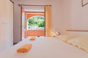 Un dormitorio con una gran cama blanca y una ventana en Near The Beach Brela Apartments Ruzze, en Brela