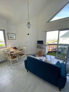 sala de estar con sofá azul y mesa en Joli appartement 4 personnes - vue mer en Ploemeur