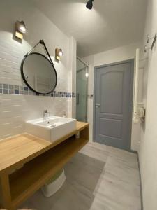een badkamer met een wastafel en een spiegel bij Joli appartement 4 personnes - vue mer in Ploemeur