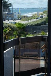 a balcony with a view of a beach and the ocean at Joli appartement 4 personnes - vue mer in Ploemeur