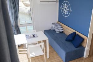 a small room with a blue couch and a table at Houseboat Floatart Experience Bisceglie in Bisceglie