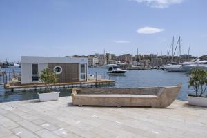 a small boat sitting on a dock with a house at Houseboat Floatart Experience Bisceglie in Bisceglie