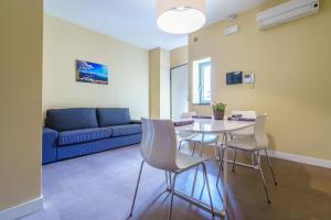 een woonkamer met een tafel en stoelen en een blauwe bank bij Holiday In Home Suite Archimede in Catania