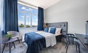 a bedroom with a bed and a desk and a window at Thon Partner Hotel Horten in Horten