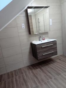 a bathroom with a sink and a mirror at Mórocz Apartman in Badacsonytomaj