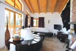a living room with a leather couch and a television at Chalet in Hochkrimml in Krimml