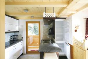 een kleine keuken met witte kasten en een wastafel bij Chalet in Hochkrimml in Krimml