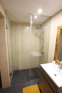 ein Bad mit einer Glasdusche und einem Waschbecken in der Unterkunft PausaSTAY - QdM Artists Suites - Rooms in Alvorge