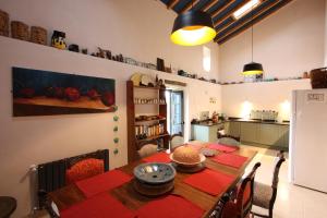 una sala da pranzo con tavolo e una cucina di PausaSTAY - QdM Artists Suites - Rooms a Alvorge