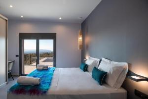 a bedroom with a large bed with a blue blanket at Exclusive Villa Petalouda in Ratzaklíon +36 photos