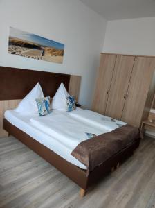 a bedroom with a bed and a dresser at Nordsee Hotel Borkum in Borkum