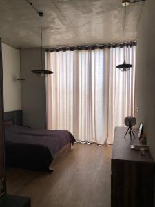 - une chambre avec un lit et une grande fenêtre dans l'établissement Villa, Kachreti Ambassador Golf Resort, à Kachretʼi