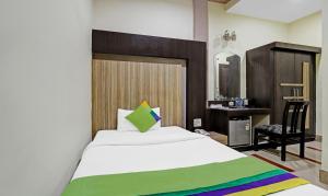 a bedroom with a large bed and a desk at Treebo Apollo in Guwahati