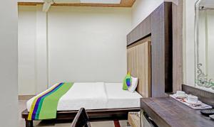 a bedroom with a bed and a desk with a table at Treebo Apollo in Guwahati