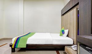 a bedroom with a bed with a colorful blanket on it at Treebo Trend Apollo in Guwahati