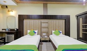 a hotel room with two beds and a mirror at Treebo Apollo in Guwahati
