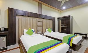 two beds in a hotel room with a rainbow bedspread at Treebo Apollo in Guwahati