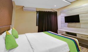 a hotel room with a bed and a flat screen tv at Treebo Apollo in Guwahati
