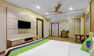 a bedroom with a large bed and a flat screen tv at Treebo Apollo in Guwahati