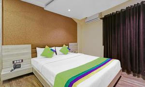 a bedroom with a large bed with a rainbow blanket at Treebo Apollo in Guwahati
