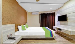 a bedroom with a bed and a flat screen tv at Treebo Apollo in Guwahati
