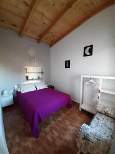 CASA LA LUNA في Isora: غرفة نوم مع سرير أرجواني وأريكة