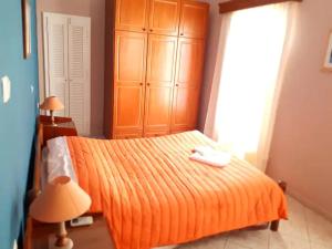 1 dormitorio con 1 cama con manta naranja en Masouri Square Apartment, en Masouri