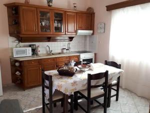 a kitchen with a table with chairs and a microwave at Masouri Square Apartment in Masouri