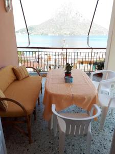 una mesa y sillas en un balcón con vistas al océano en Masouri Square Apartment, en Masouri