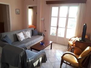 a living room with a couch and a tv at Masouri Square Apartment in Masouri