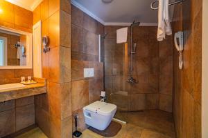 a bathroom with a shower and a toilet and a sink at Senza The Inn Resort & Spa - Ultra All Inclusive in Avsallar