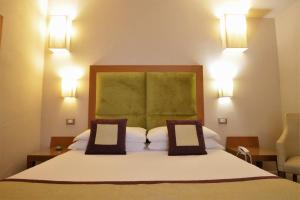 um quarto com uma cama grande e 2 almofadas em Hotel Perseo em Florença