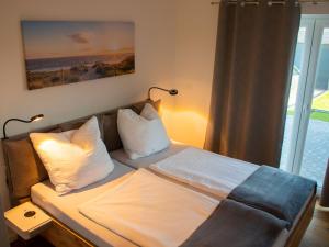 sypialnia z łóżkiem, kanapą i oknem w obiekcie Ferienhäuser Rüno w mieście Bergen auf Rügen