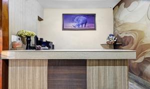 a reception desk in a hotel room with a picture of an elephant at Treebo Apollo in Guwahati