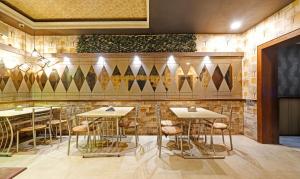 un restaurant avec des tables et des tabourets dans une pièce dans l'établissement Treebo Trend Apollo, à Guwahati