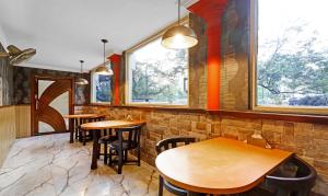 a row of tables in a restaurant with windows at Treebo Apollo in Guwahati