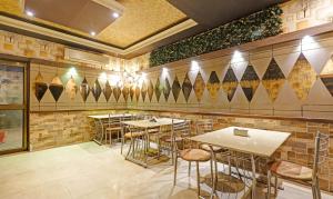 a restaurant with tables and chairs in a room at Treebo Apollo in Guwahati